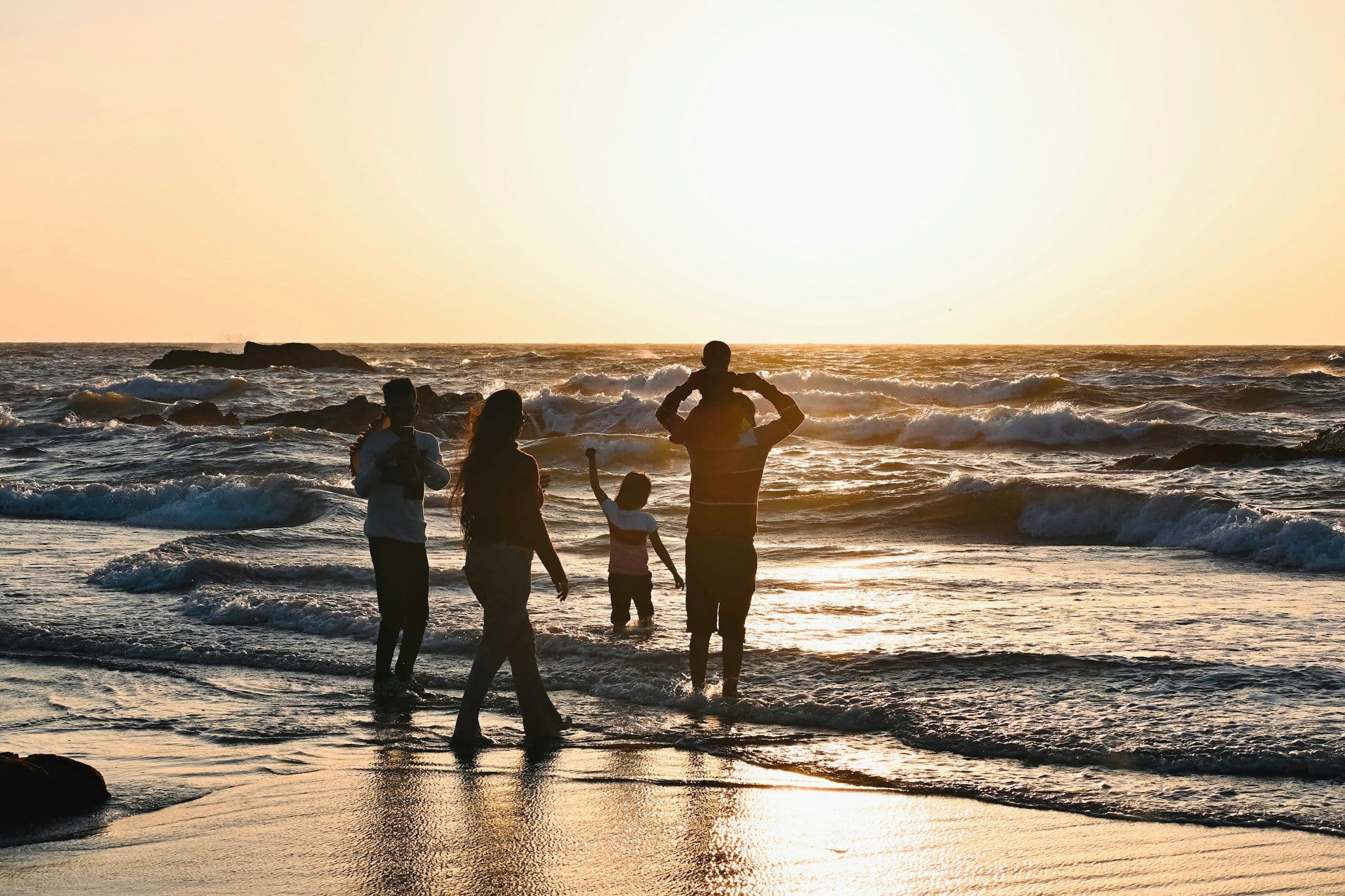 Família caminhando junta em uma praia tropical